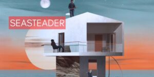 A person reclines on a chair on the porch of a home sitting on top of a spar in the middle of the ocean.